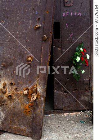 Bullet holes in the metal door of the residential building. Bullet holes in the metal door of the residential building. 97576264