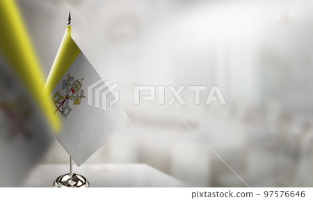 Small flags of the Vatican on an abstract blurry background 97576646