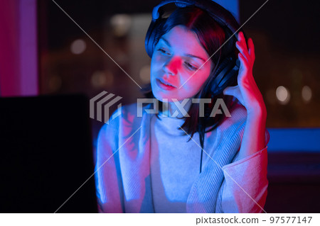 Girl is listening music at home at night. Girl is listening music at home at night. 97577147