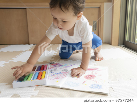 A boy painting with crayons A boy painting with crayons 97577244