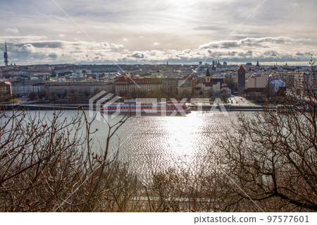 Vltava river - shining in sunbeams of winter sunrise with some ship next to shores and buildings in Prague Vltava river - shining in sunbeams of winter sunrise with some ship next to shores and buildings in Prague 97577601
