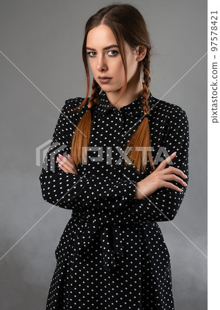 portrait of a mysterious girl with pigtails and a black dress.grey background with smoke portrait of a mysterious girl with pigtails and a black dress.grey background with smoke 97578421