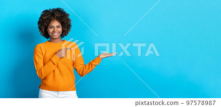 Positive african american young woman showing empty space Positive african american young woman showing empty space 97578987