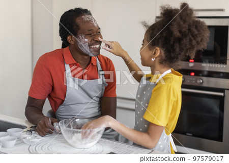 Happy Black Father And Daughter Bonding While Baking Together In Kitchen 97579017
