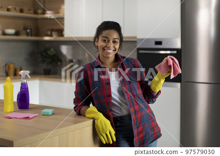 Glad millennial african american female in rubber gloves with rag near table enjoy household chores 97579030