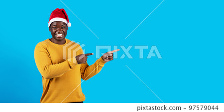 Xmas Offer. Cheerful Black Guy In Santa Hat Pointing At Copy Space Xmas Offer. Cheerful Black Guy In Santa Hat Pointing At Copy Space 97579044