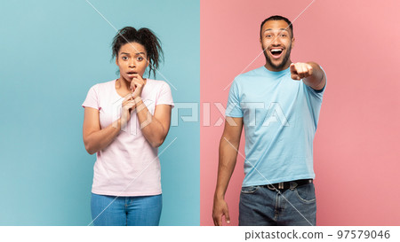 Shocked black couple gaze straightly at camera, happy man pointing at something, impressed woman looking with excitement Shocked black couple gaze straightly at camera, happy man pointing at something, impressed woman looking with excitement 97579046