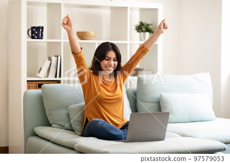 Good News. Happy Young Arab Woman Celebrating Success With Laptop At Home 97579053