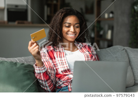 New buy and app for pay. Happy millennial black lady using computer and credit card to check bank account New buy and app for pay. Happy millennial black lady using computer and credit card to check bank account 97579143