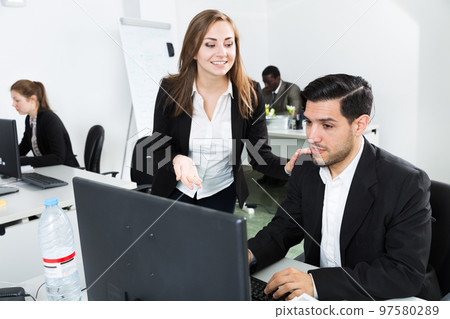 Business woman explaining something to male coworker 97580289
