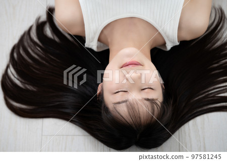 穿著背心的年輕女子躺在地板上 97581245