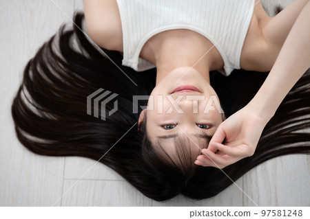 穿著背心的年輕女子躺在地板上 97581248