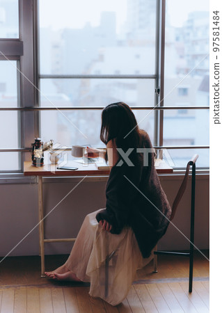 一位年輕女子在她的房間裡看書的照片 一位年輕女子在她的房間裡看書的照片 97581484