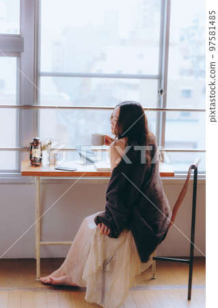 一位年輕女子在她的房間裡看書的照片 一位年輕女子在她的房間裡看書的照片 97581485