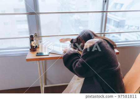Photo of a young woman reading in her room 97581811