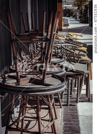Stack of Round table and Dark green (Khaki color), Yellow plastic chairs are beside of The cafe terrace. Stack of Round table and Dark green (Khaki color), Yellow plastic chairs are beside of The cafe terrace. 97581936