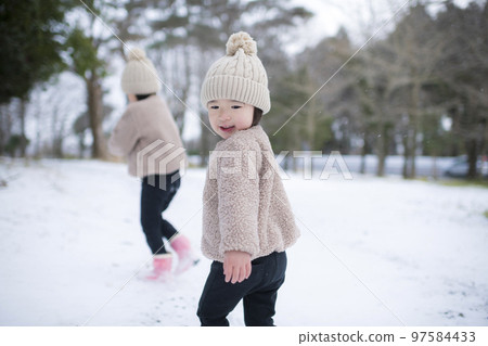 冬天戴著針織帽在雪地裡玩耍的女孩姐妹 97584433