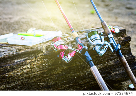 fishing gear on the shore. Two spinning rods and lures spinning rod 97584674