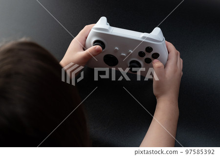 Kid hold white game joystick 97585392