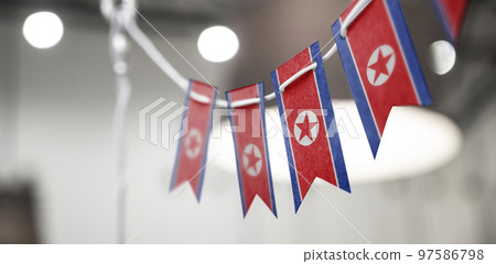 A garland of North Korea national flags on an abstract blurred background 97586798