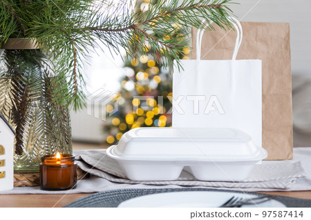 Food delivery service containers on table in white kitchen, festively served for celebration of Christmas and new year.  Saving time, hot order, disposable plastic box, craft package. mock up 97587414