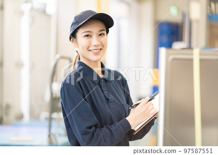 Young female worker working in distribution warehouse Young female worker working in distribution warehouse 97587551