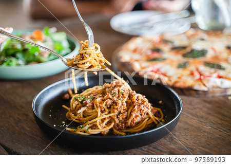 Eating food. people eating Italian food Pasta, Pizza, Salad on the table. 97589193
