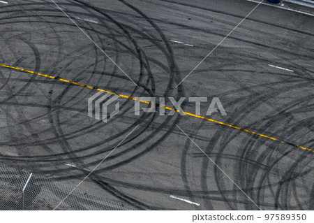 Tire track mark on asphalt tarmac road race track texture and background, Abstract background black tire tracks skid on asphalt road in racing circuit, Tire mark skid mark on asphalt road. 97589350