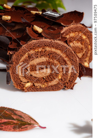 Sliced log-shaped chocolate roll with buttercream and hazelnuts Sliced log-shaped chocolate roll with buttercream and hazelnuts 97589475