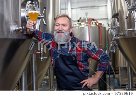 Brewery owenr tasting fresh beer and looking interested Brewery owenr tasting fresh beer and looking interested 97589619