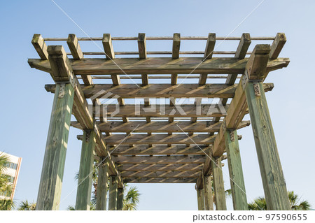View of a wooden grid pergola roof from below against the sky at Destin, Florida 97590655