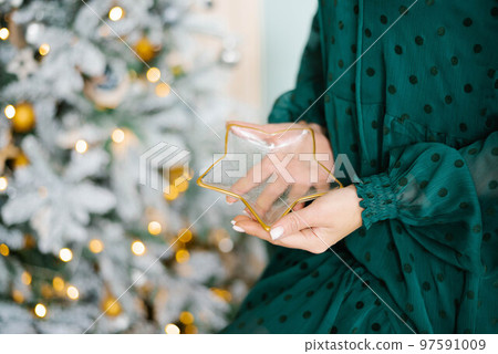 A woman holds a glass plate in the shape of a star. Close-up of hands 97591009