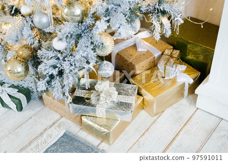 Silver and gold gifts for Christmas and New Year under the tree Silver and gold gifts for Christmas and New Year under the tree 97591011