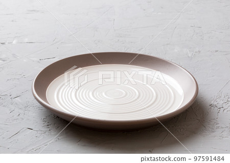 Perspective view of empty light plate on cement background. Empty space for your design Perspective view of empty light plate on cement background. Empty space for your design 97591484