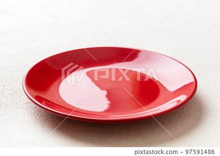Perspective view of empty red plate on cement background. Empty space for your design Perspective view of empty red plate on cement background. Empty space for your design 97591486