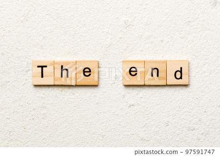 The end word written on wood block. The end text on cement table for your desing, concept 97591747