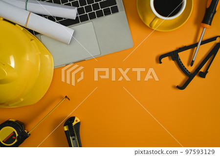 Top view of laptop computer, blueprints and hardhat on yellow background. Copy space for your text Top view of laptop computer, blueprints and hardhat on yellow background. Copy space for your text 97593129