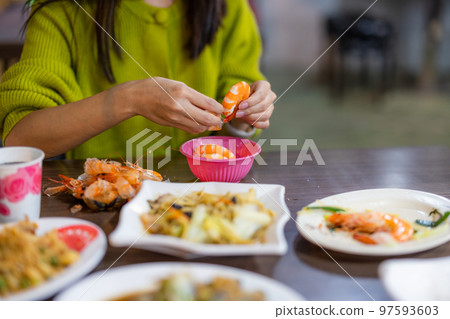 Woman peel off shrimp at restaurant 97593603