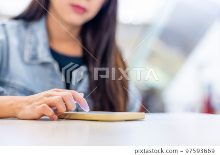 Woman use mobile phone and put it on table Woman use mobile phone and put it on table 97593669