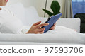 Woman hold with tablet computer and sit on sofa at home 97593706