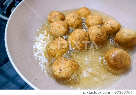 An Indian Street Food Group of Frying Pakora or Bhajiya in oil 97593765