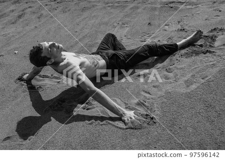man sitting on the sand in sandy desert 97596142