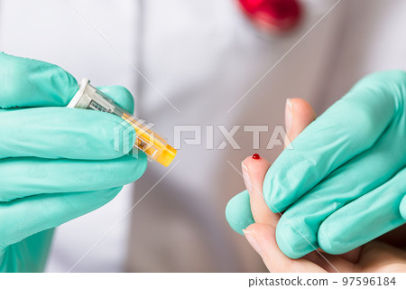 Doctor piercing patients finger with lancet in clinic closeup. Taking blood for close-up analysis, a clinical blood test 97596184
