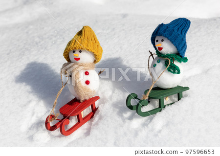Snowmen playing sledding 97596653