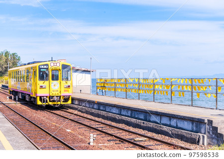 A yellow train with a beautiful sea in the background "Daisami-Higashi Station" A tourist attraction famous for yellow handkerchiefs and commercial filming locations: Shimabara City, Nagasaki Prefecture 97598538