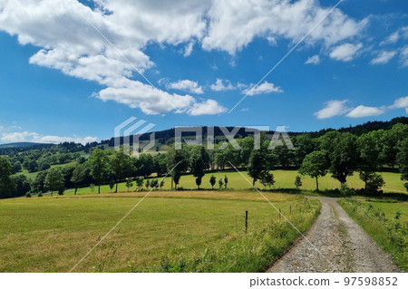 Beautiful view of the mountains and the green meadow on a sunny summer day. Beautiful view of the mountains and the green meadow on a sunny summer day. 97598852