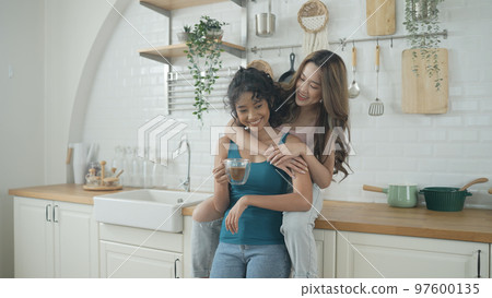 Holiday concept of 4k Resolution. Asian women having coffee together in the kitchen. Young women are in a mutual lesbian love relationship. 97600135