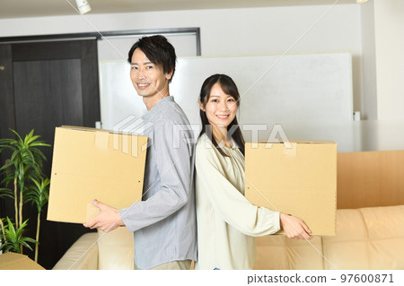A couple of men and women packing in cardboard boxes A couple of men and women packing in cardboard boxes 97600871