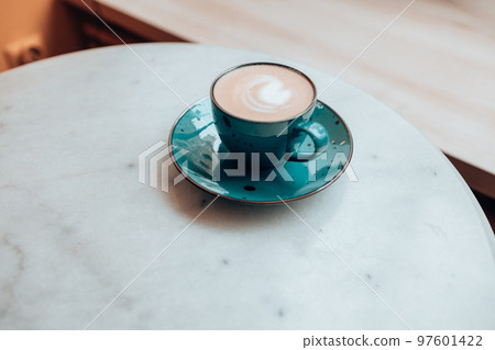 closeup of a cup of latte coffee on white marble table, cafe, copy space 97601422