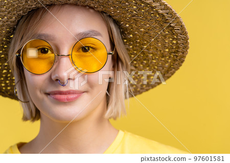 Portrait of young pretty blonde woman on summer yellow studio background. Confident sunny outfit Portrait of young pretty blonde woman on summer yellow studio background. Confident sunny outfit 97601581